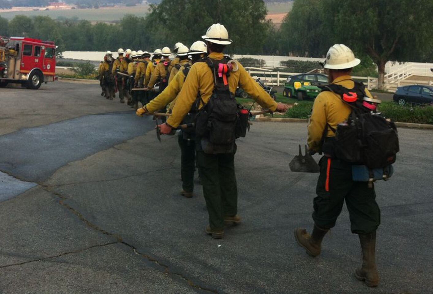 A fire crew heads out to do mop-up work in Thousand Oaks early Saturday morning.