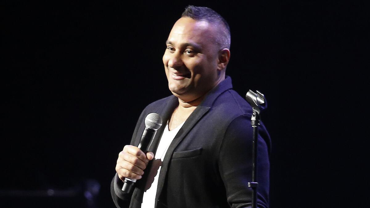 Russell Peters performs on stage.