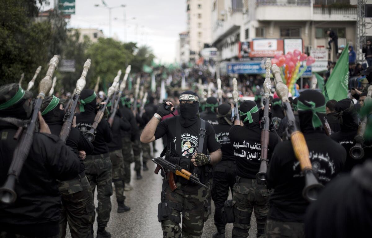 Masked members of the Hamas Palestinian militant group attend a rally to commemorate the 27th anniversary of the group in Gaza City.