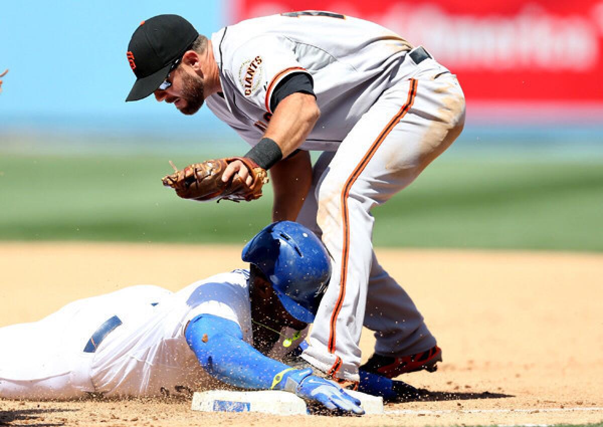 Dodgers right fielder Yasiel Puig is tagged out by Giants second baseman Brandon Hicks after getting caught in a rundown on Friday afternon.