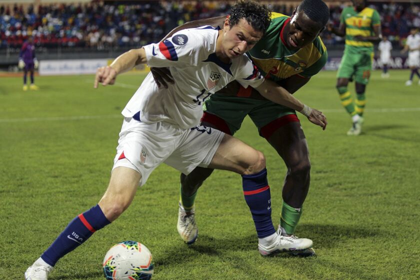U.S. Brenden Aaronson, left, fights for the ball with Grenada's Benjamin Ettienne, during a CONCACAF Nations League soccer match in Saint George, Grenada, Friday, March 24, 2023. (AP Photo/Haron Forteau)