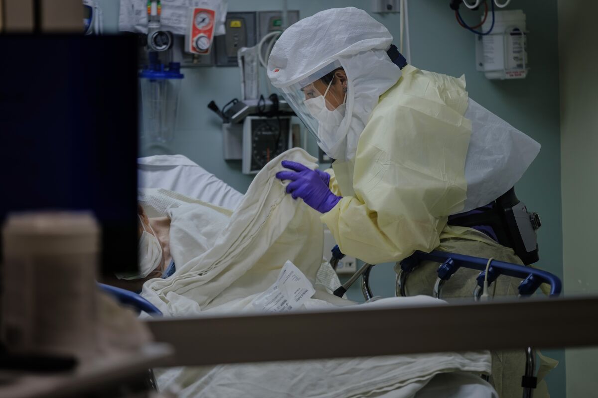 Wearing personal protective equipment, Registered Nurse April Bandi cares for a patient that has possible COVID-19 symptoms inside a special negative pressure isolation room at the Emergency Department at Sharp Memorial Hospital in San Diego on April 10, 2020.