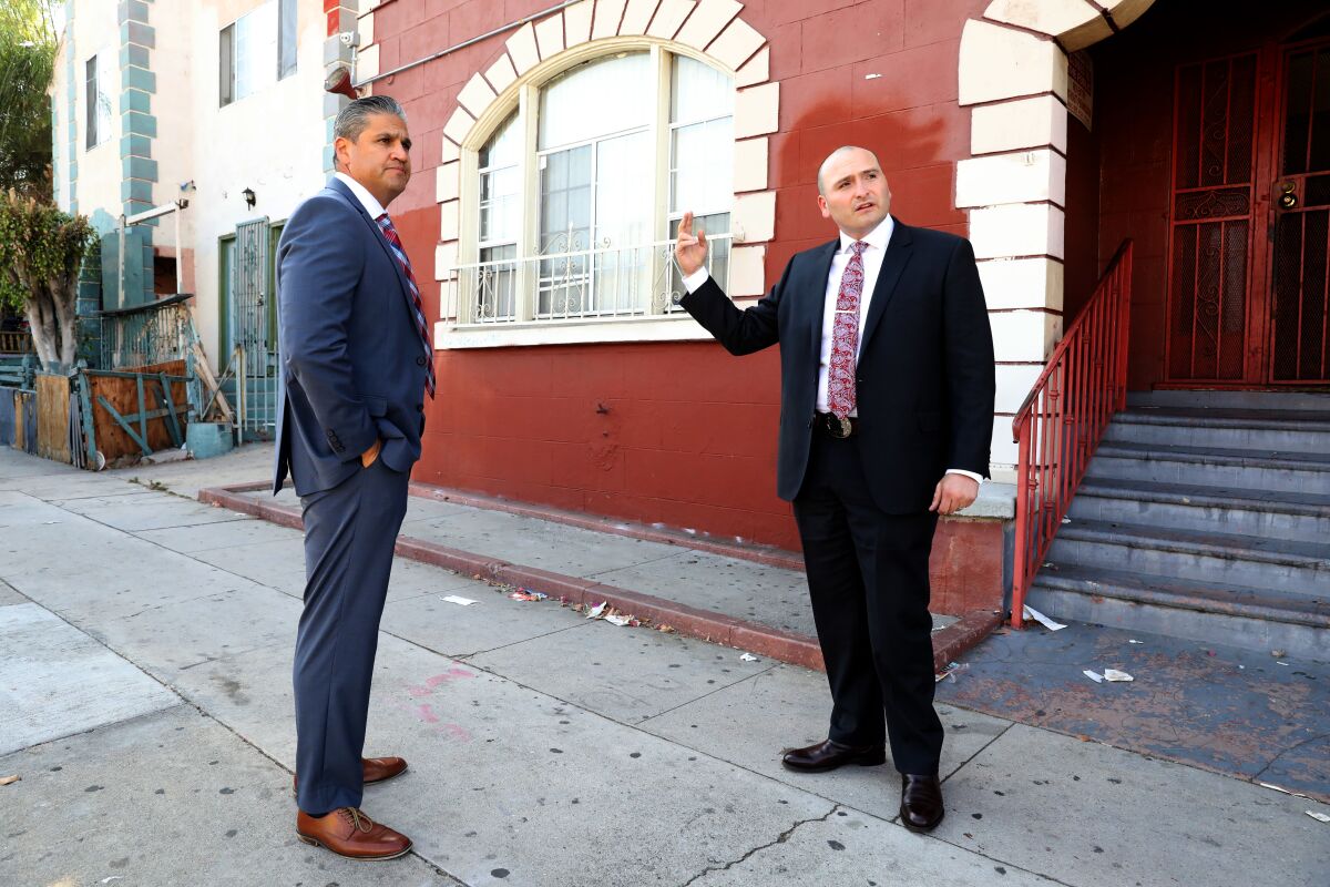 LAPD Homicide Detectives Jason Sharman, left, and John Meneses stand on a sidewalk