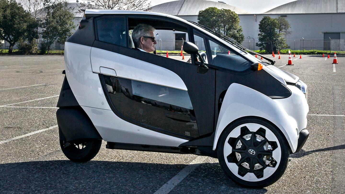 A driver takes a test spin in the Toyota concept vehicle called the iRoad.