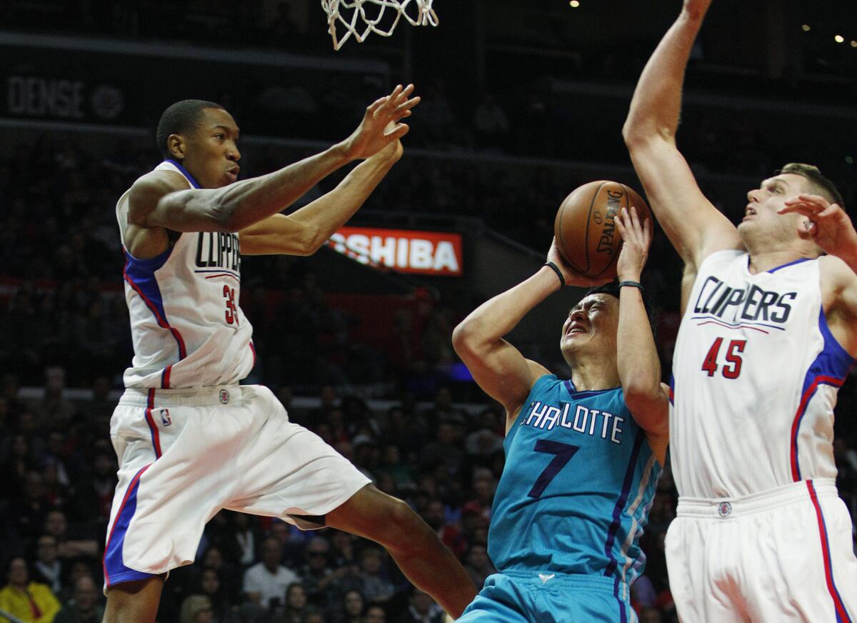 Hornets guard Jeremy Lin (7) tries to score between Clippers forward Wesley Johnson (33) and center Cole Aldrich (45) during the second half.