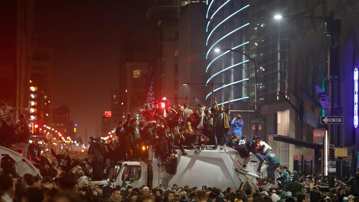 Eagles fans take to the tops of trucks during their Super Bowl celebration.