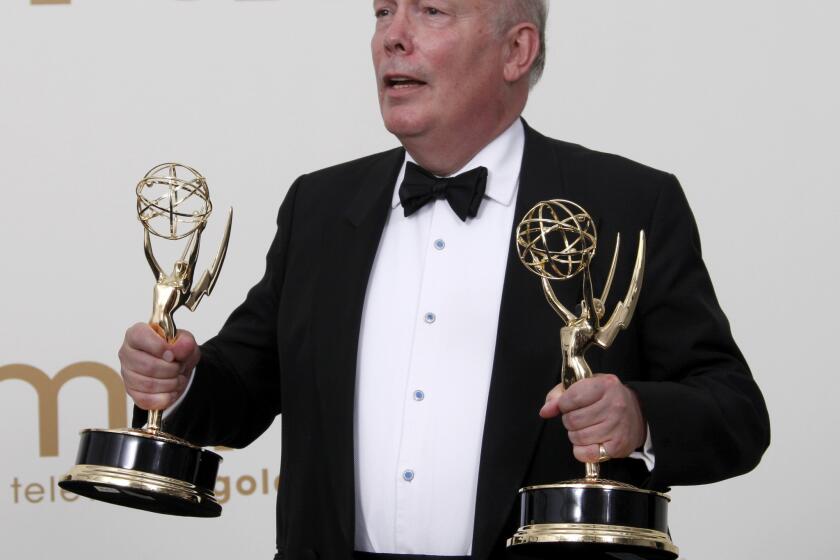 "Downton Abbey" creator Julian Fellowes holds Emmys awarded to his series in 2011.