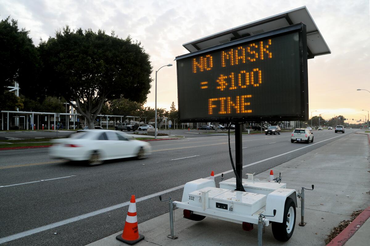 A sign in November 2020 along Fair Drive warns residents and visitors that "no mask = $100 fine" in Costa Mesa. 