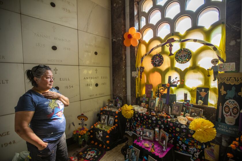 East Los Angeles, CA - October 28: Ana Cuevas, 51, of Norwalk at Calvary Cemetery and Mortuary on Friday, Oct. 28, 2022, in East Los Angeles, CA. Ana is building an altar to honor 14 of her relatives and friends who have died. Ana explained that she lost her 88-year-old grandmother and 1-year-old nephew to covid last year and they are also being honored in her alter. Tomorrow there will be a Dia de Los Muertos Community Day celebration at the cemetery including a Mass at noon, the blessing of alters, music and folklorico dance at 1:30 pm. (Francine Orr / Los Angeles Times)