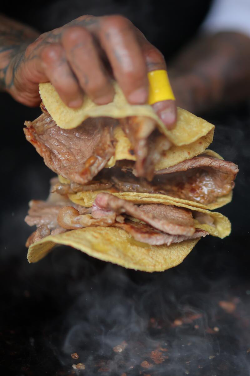 Detail as griller Jacinto Rodriguez works preparing tacos during a visit to 'El Califa de Leon' on