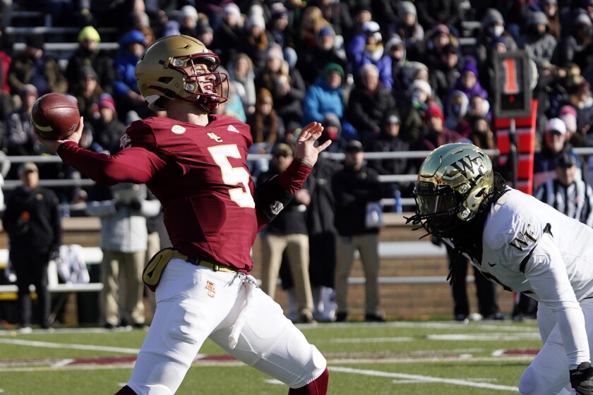 Boston College quarterback Phil Jurkovec (5) passes under pressure from Wake Forest defensive lineman Luiji Vilain (2) during the first half of an NCAA college football game, Saturday, Nov. 27, 2021, in Boston. (AP Photo/Mary Schwalm)