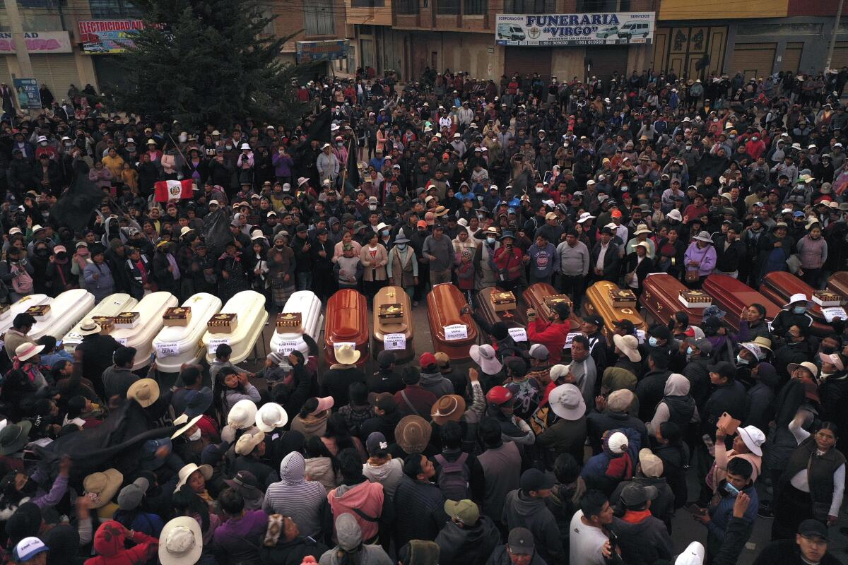 Mourners surrounding coffins 