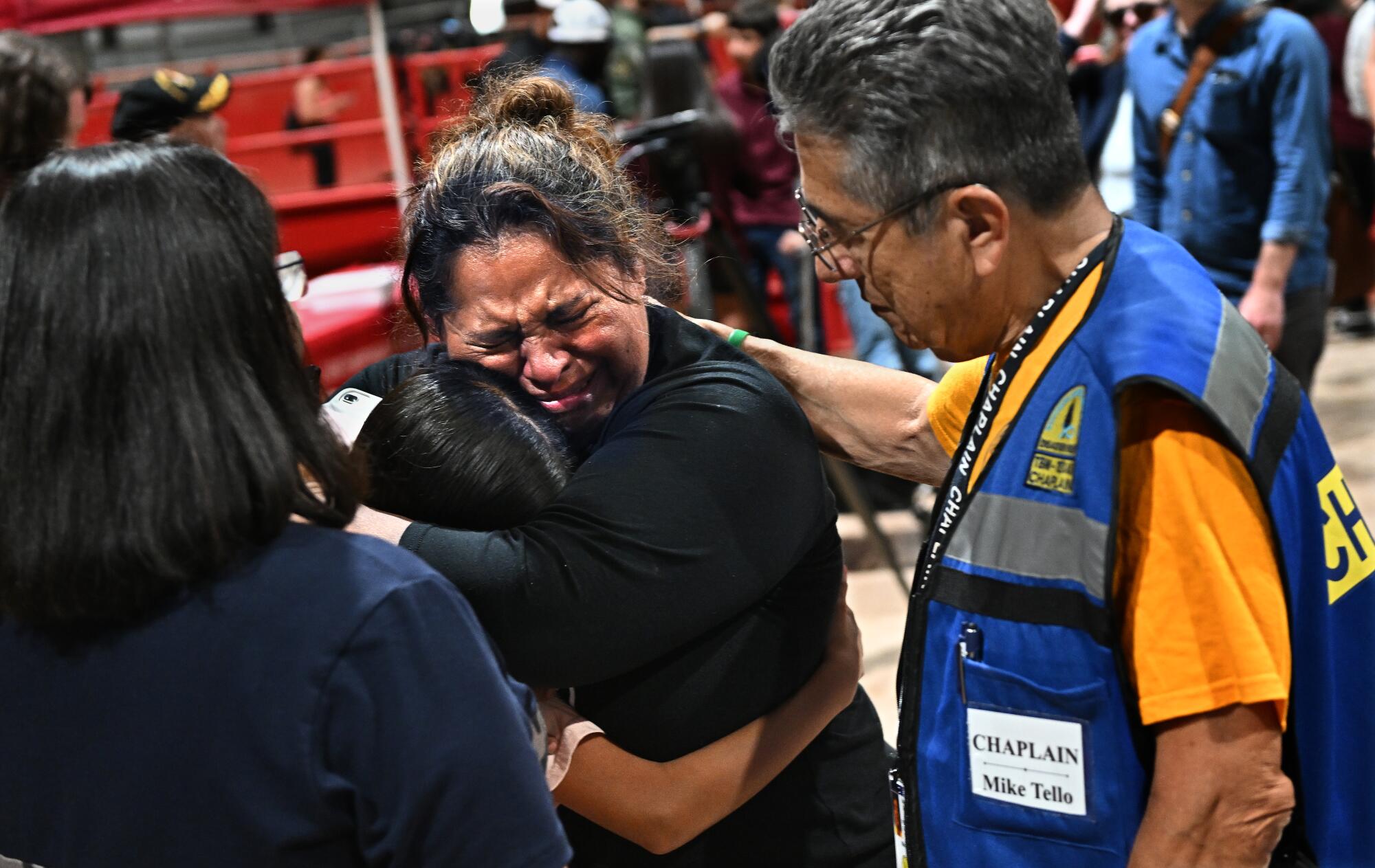 A fourth-grade teacher at Robb Elementary School consoles her student after a vigil at the Uvalde County Fairplex.