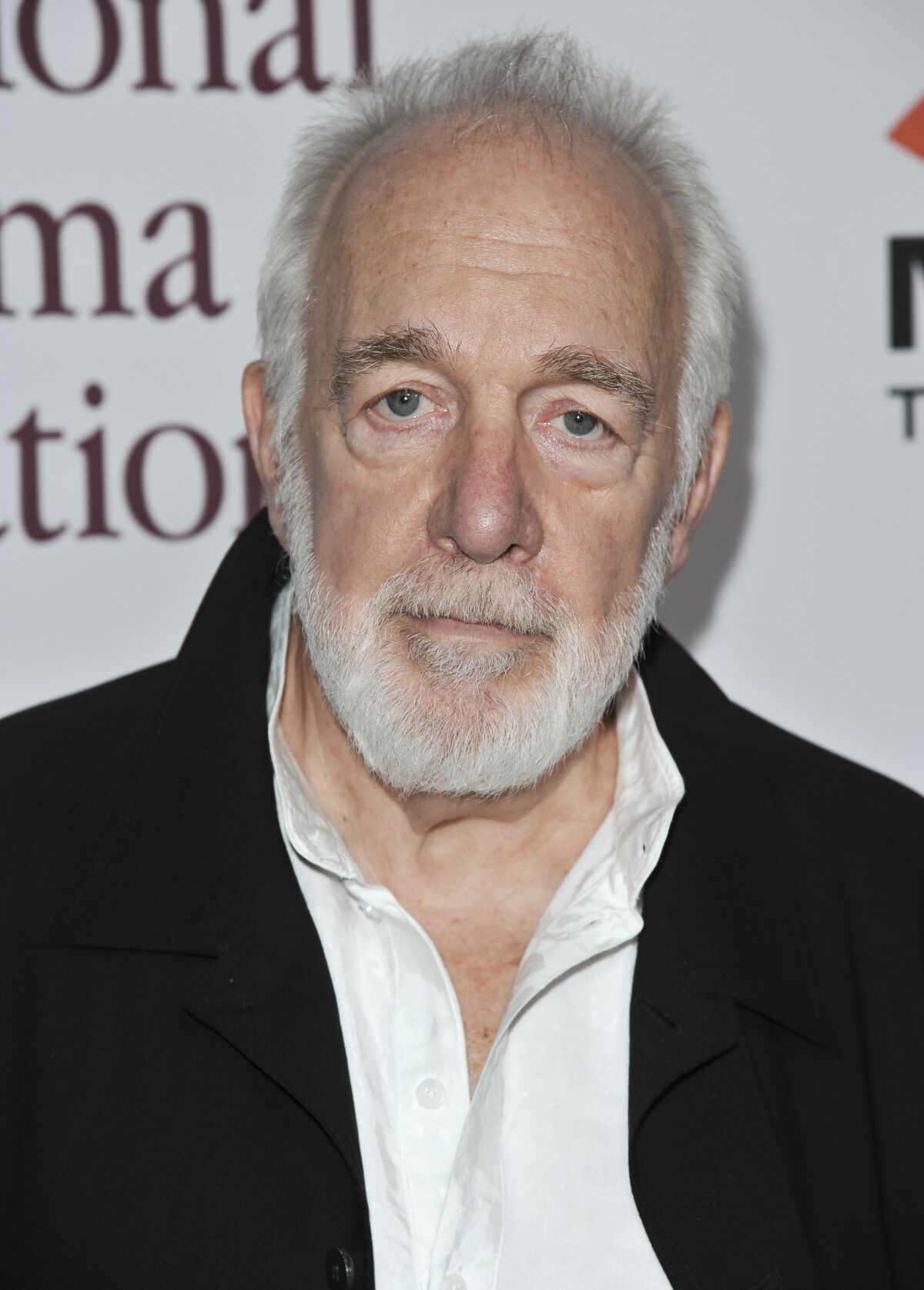 A silver-haired man with a beard. 
