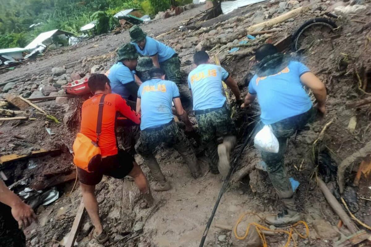 Rescuers retrieve bodies during the search and rescue operations due to landslides.