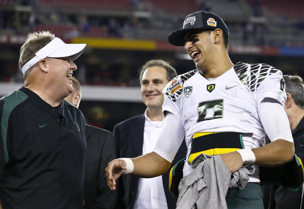 Oregon head coach Chip Kelly, left, laughs with Marcus Mariota after the Fiesta Bowl.