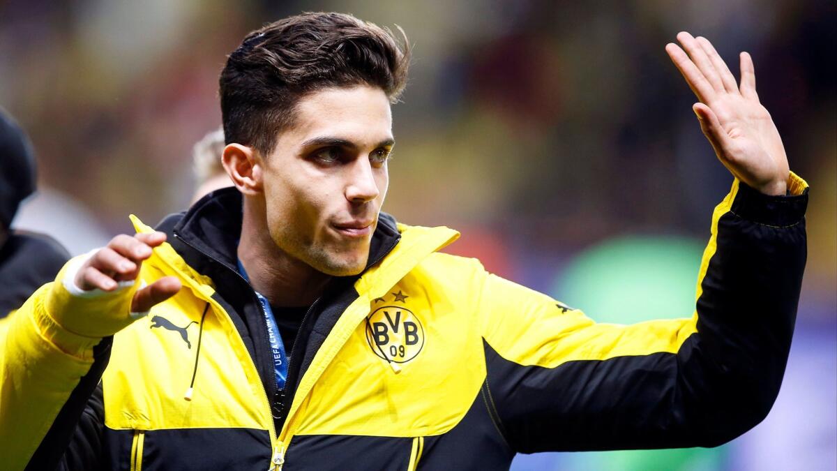 Borussia Dortmund defender Marc Bartra, who was seriously injured in a bomb attack on a team bus, acknowledges fans at a recent game.