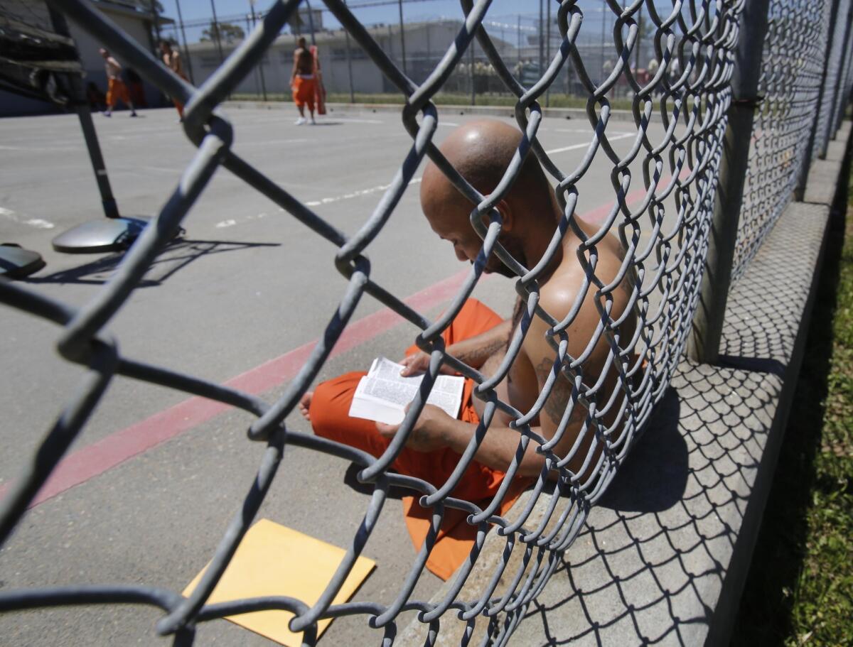 Inmate Curtis Colvard Sr. reads a Bible in the exercise yard of Sacramento County's Rio Cosumnes Correctional Center in Elk Grove. Federal judges ordered Gov. Jerry Brown Thursday to immediately begin releasing inmates from the state's crowded prisons.