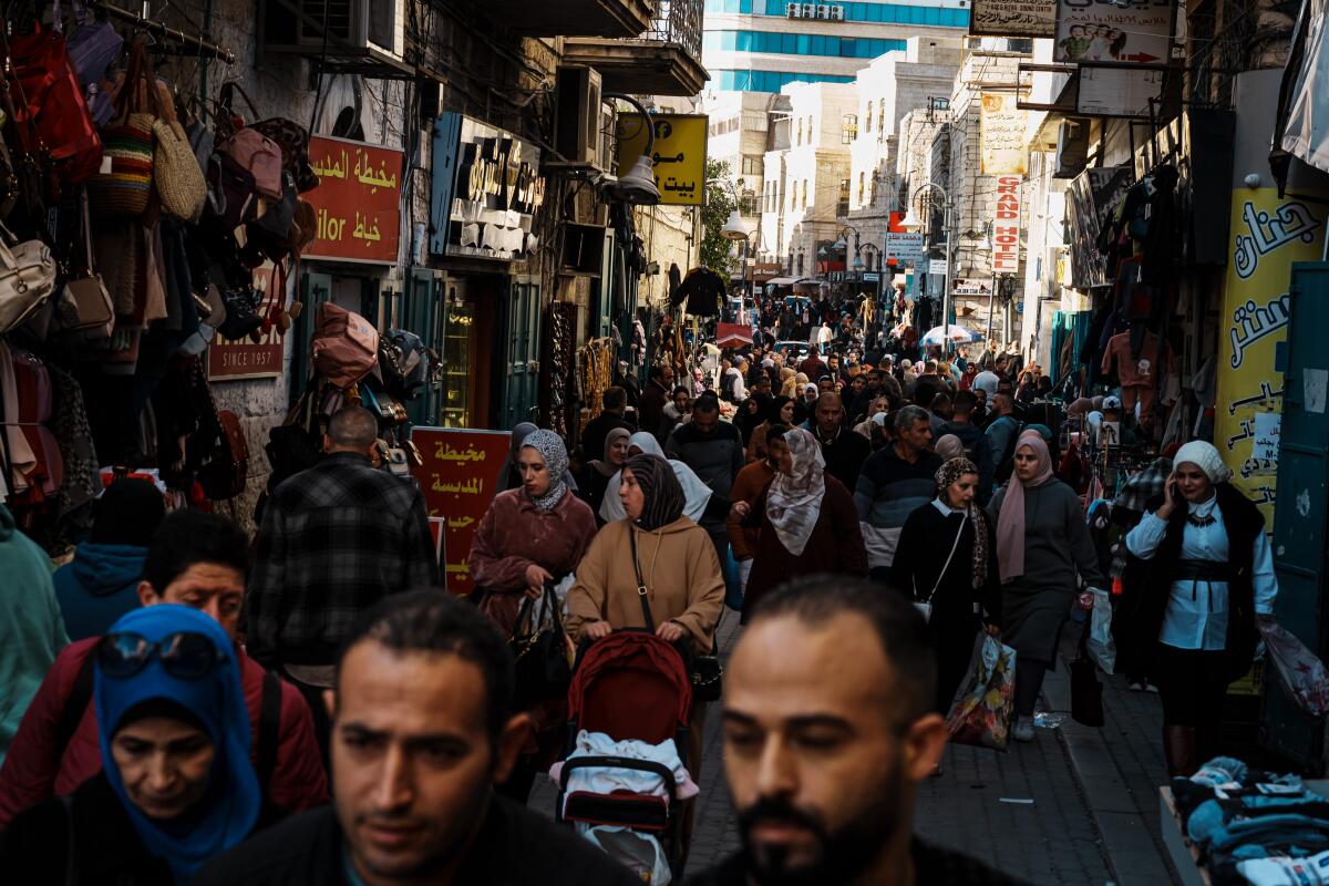 People crowd a busy market street in Bethlehem.