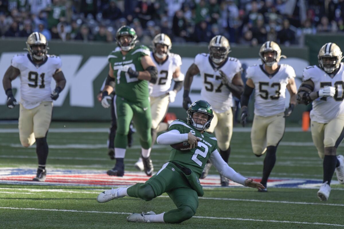 New York Jets quarterback Zach Wilson (2), center, slides after carrying the ball during the first half of an NFL football game against the New Orleans Saints, Sunday, Dec. 12, 2021, in East Rutherford, N.J. (AP Photo/Bill Kostroun)