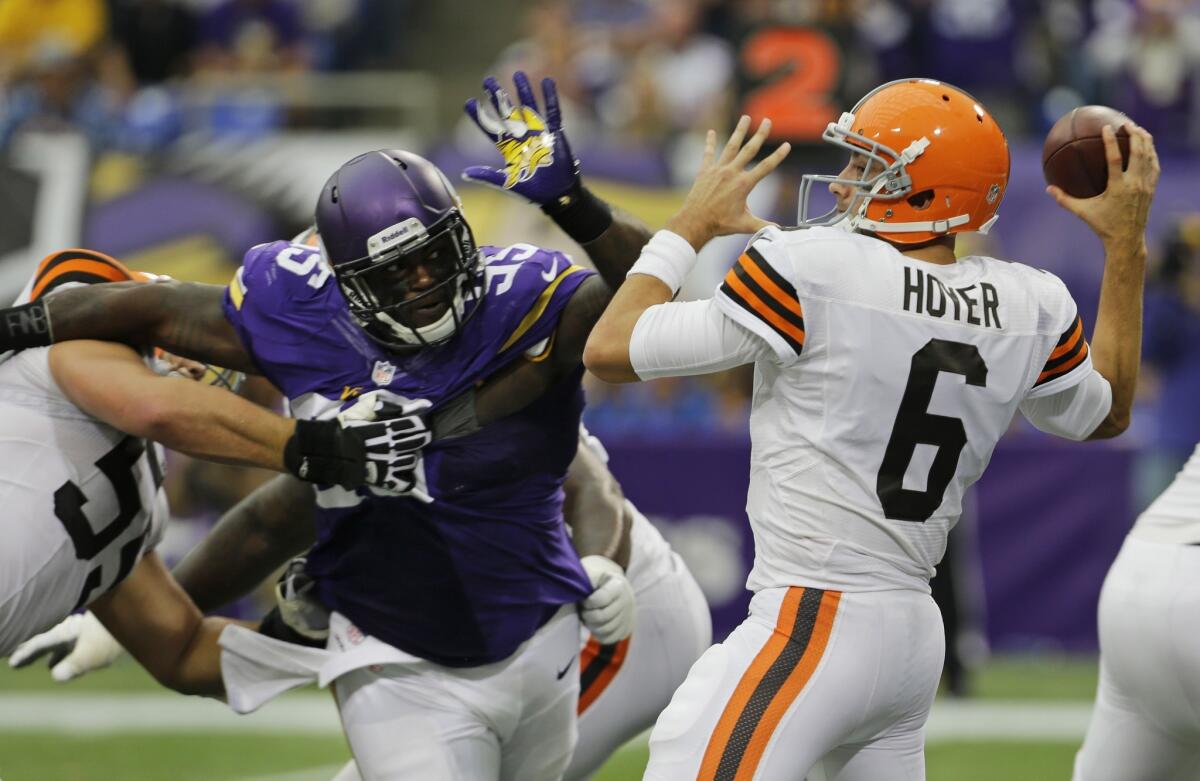 Cleveland Browns quarterback Brian Hoyer, right, is pressured by Minnesota Vikings defensive tackle Sharrif Floyd during the second half of the Browns' 31-27 win Sunday.