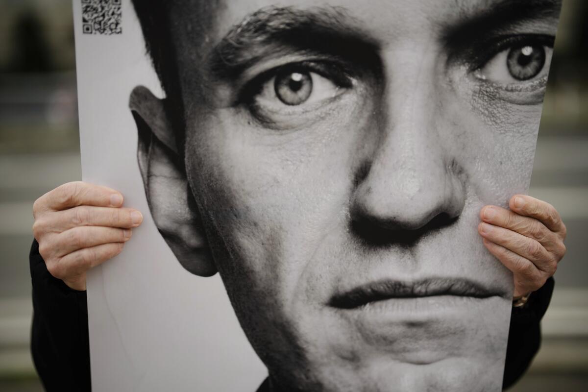 A person holds a poster with a portrait of Alexei Navalny during a protest.