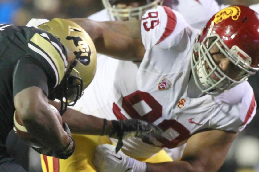 USC defensive tackle Antwaun Woods makes a tackle against Colorado in 2013.