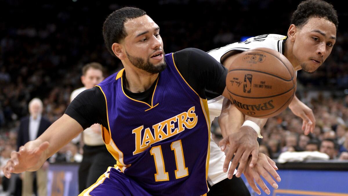 Lakers guard Tyler Ennis (11) chases after a loose ball against Spurs guard Bryn Forbes during the second half on April 5.