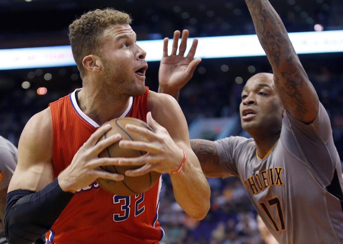 Clippers forward Blake Griffin protects the ball as he drives to the basket against Phoenix Suns forward P.J. Tucker.