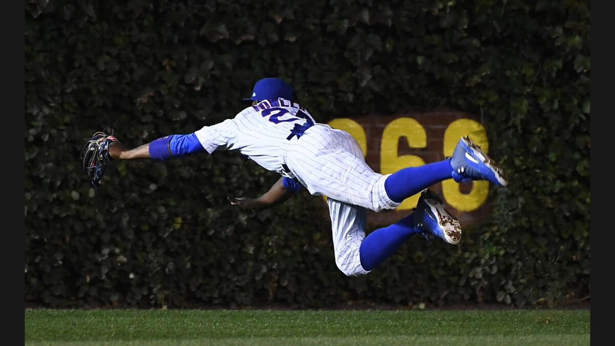 Cubs center fielder Dexter Fowler makes a diving catch off a deep fly ball hit by Dodgers catcher Carlos Ruiz in the fourth inning in Game 1.