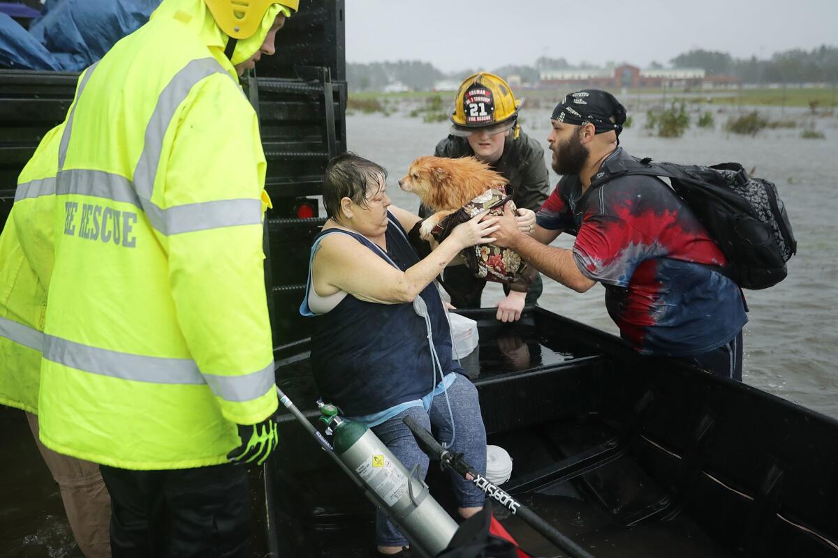 Fire department personnel and Civilian Crisis Response Team volunteers help rescue a woman and her dog from their home in James City, N.C.