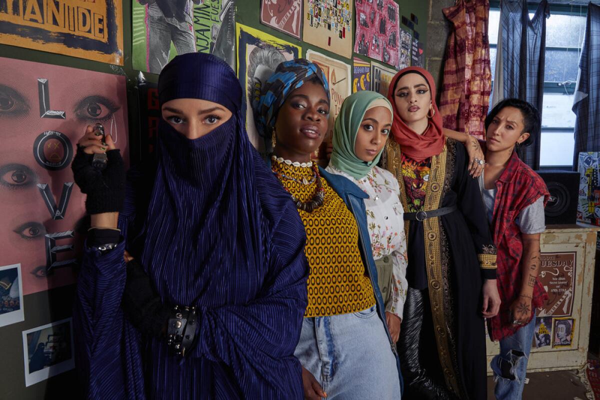 Five teenage girls lined up along a bedroom wall