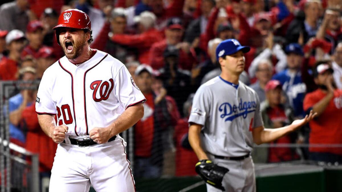 Nationals second baseman Daniel Murphy celebrates after scoring a run against the Dodgers and pitcher Rich Hill (background) in the second inning of Game 5 of the NLDS on Thursday in Washington. To see more images, click on the photo.