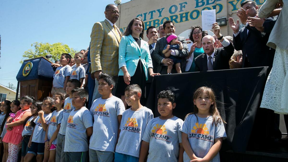 Surrounded by residents, local and state politicians, Gov. Jerry Brown signs legislation to monitor and reduce pollution in neighborhoods with the dirtiest air.