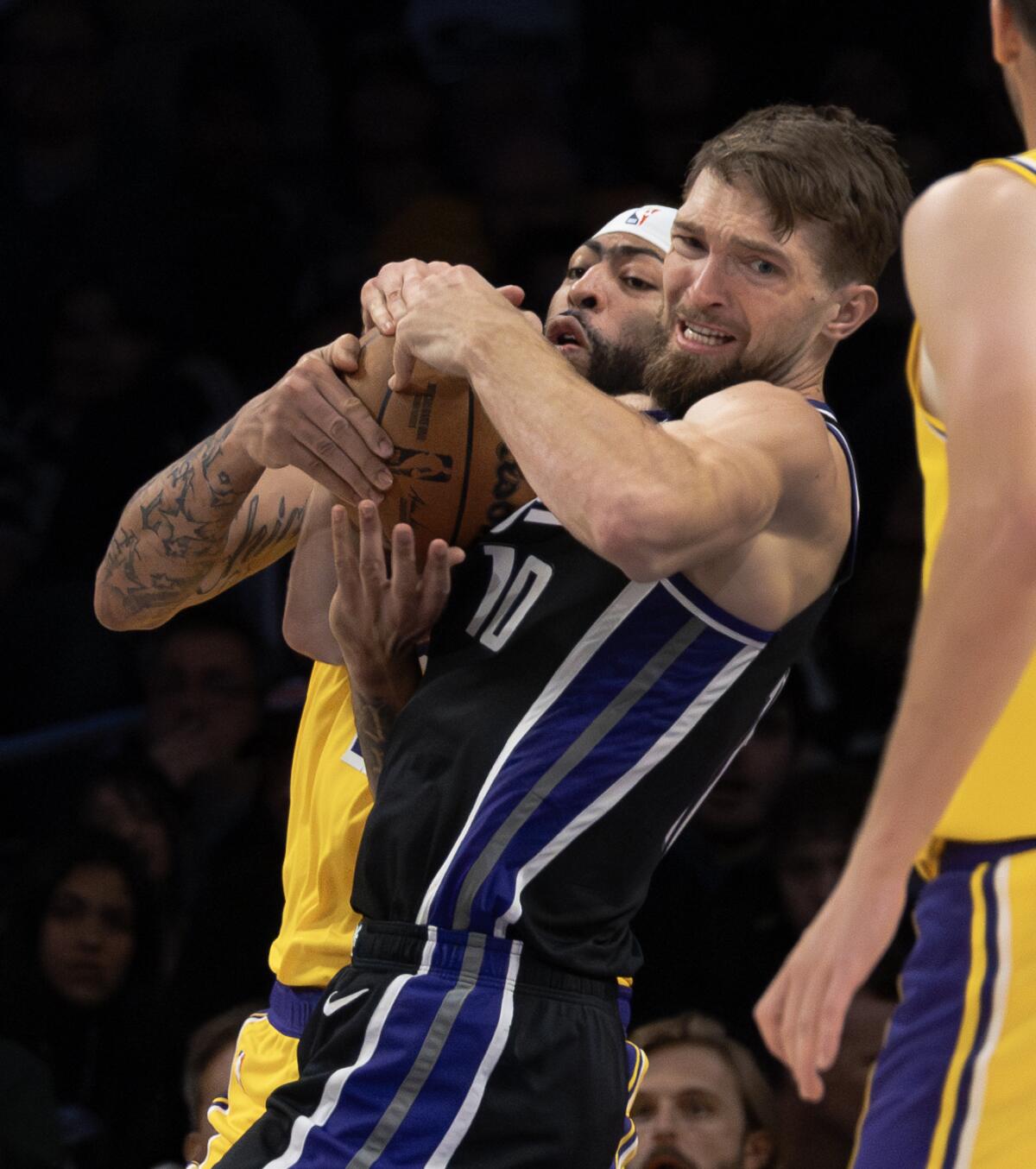 Lakers forward Anthony Davis tangles with Kings forward Domantas Sabonis for a rebound at Crypto.com Arena.