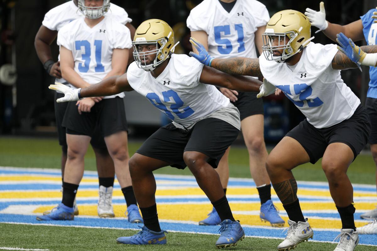 UCLA's Osa Odighizuwa (92) and Lokeni Toailoa (52) go through punt formation drills at fall football camp practice at the football fields at the Wasserman Football Center on the campus of UCLA.
