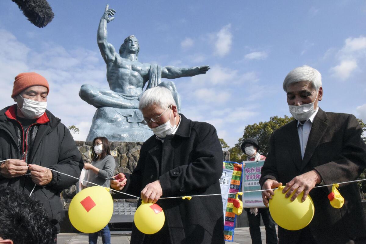 People deflate balloons in symbolic hope of demolishing nuclear warheads at a gathering in Nagasaki, Japan, on Friday.