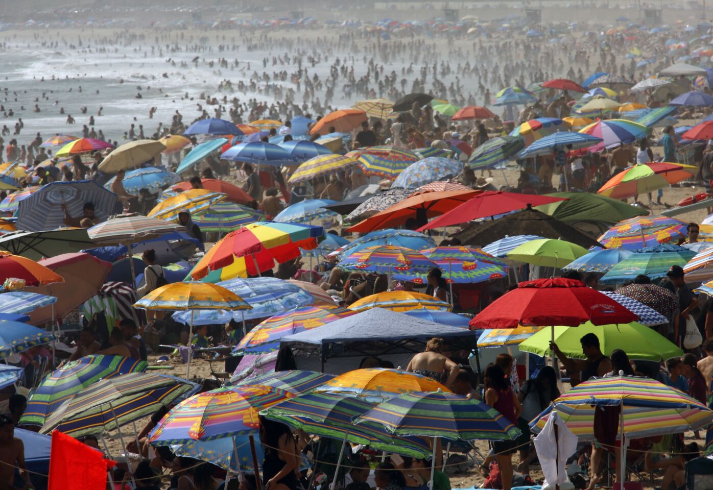 Hundreds of people seek relief from the hot weather in the surf Sunday along the Santa Monica Pier.