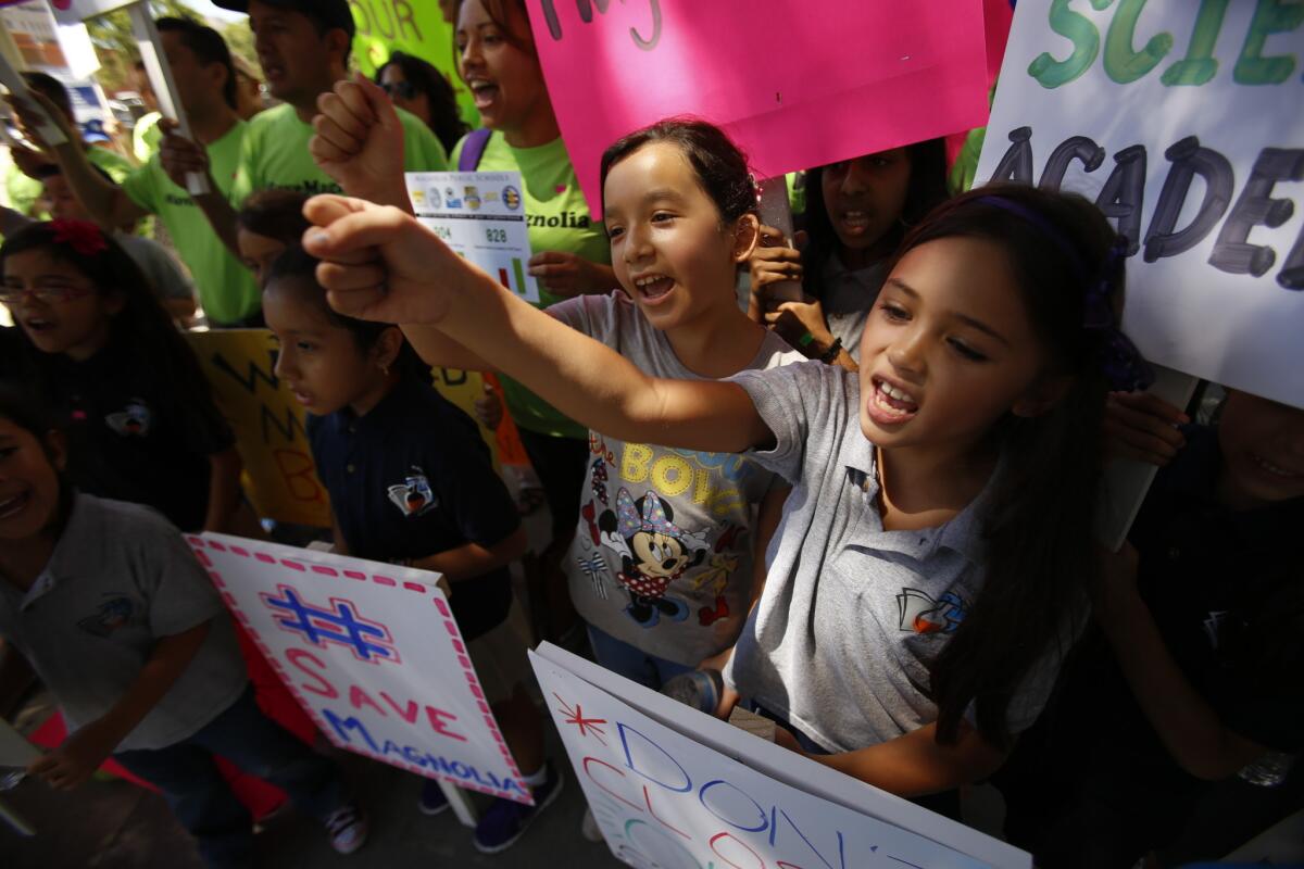 Makayla Bigler, 8, left, and Breeana Alano, 7, join parents and students protesting a decision by L.A. Unified not to renew two schools'charters.