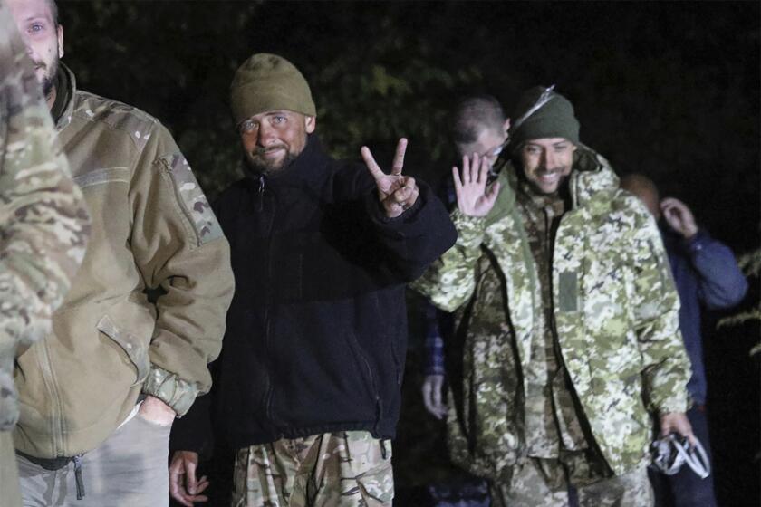 In this photo provided by the Ukrainian Security service Press Office, Ukrainian soldiers, who were released in a prisoner exchange between Russia and Ukraine, smile close to Chernihiv, Ukraine, late Wednesday, Sept. 21, 2022. Ukraine announced a high-profile prisoner swap early Thursday that culminated months of efforts to free many of the Ukrainian fighters who defended a steel plant in Mariupol during a long Russian siege. (Ukrainian Security service Press Office via AP)