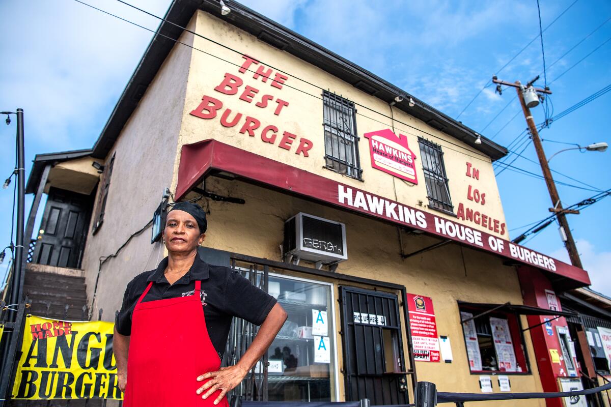 Cynthia Hawkins stands outside her restaurant, Hawkins House of Burgers, whose sign says The Best Burger in Los Angeles