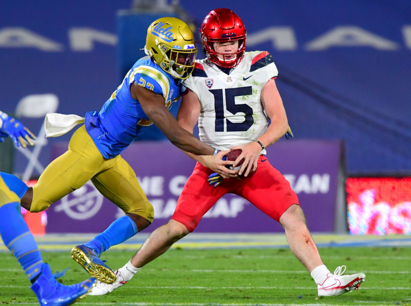UCLA defensive back Obi Eboh strips the ball from Arizona quarterback Will Plummer.