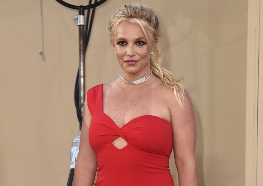 Britney Spears in a red off-the-shoulder dress