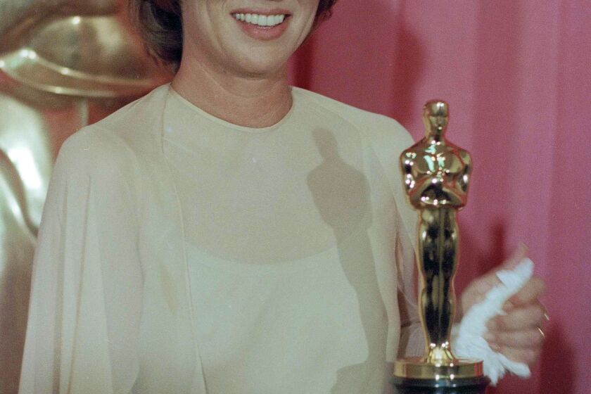 FILE - Louise Fletcher holds the Academy Award she won for her leading role in "One Flew Over The Cuckoo's Nest" in Los Angeles, March 30, 1976. Fletcher, a late-blooming star whose riveting performance as the cruel and calculating Nurse Ratched in “One Flew Over the Cuckoo's Nest” set a new standard for screen villains and won her an Academy Award, died Friday, Sept. 23, 2022, at age 88. (AP Photo/File)