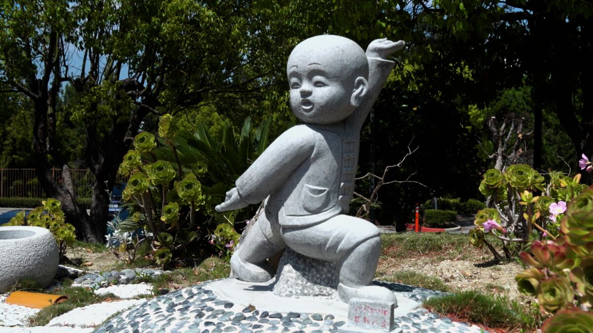 A little Buddha statue lunging forward and stretching one arm behind and one in the air