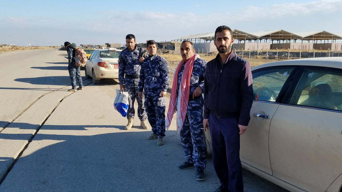 Taxi driver Hoshyar Faisal Qasim, right, said he tries to avoid driving his taxi through especially dangerous parts of Mosul, helps wounded passengers and turns in those he finds suspicious.