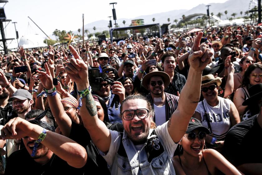 Festival goers cheer as Los Angeles Azules starts performing during Day 1 of the Coachella 