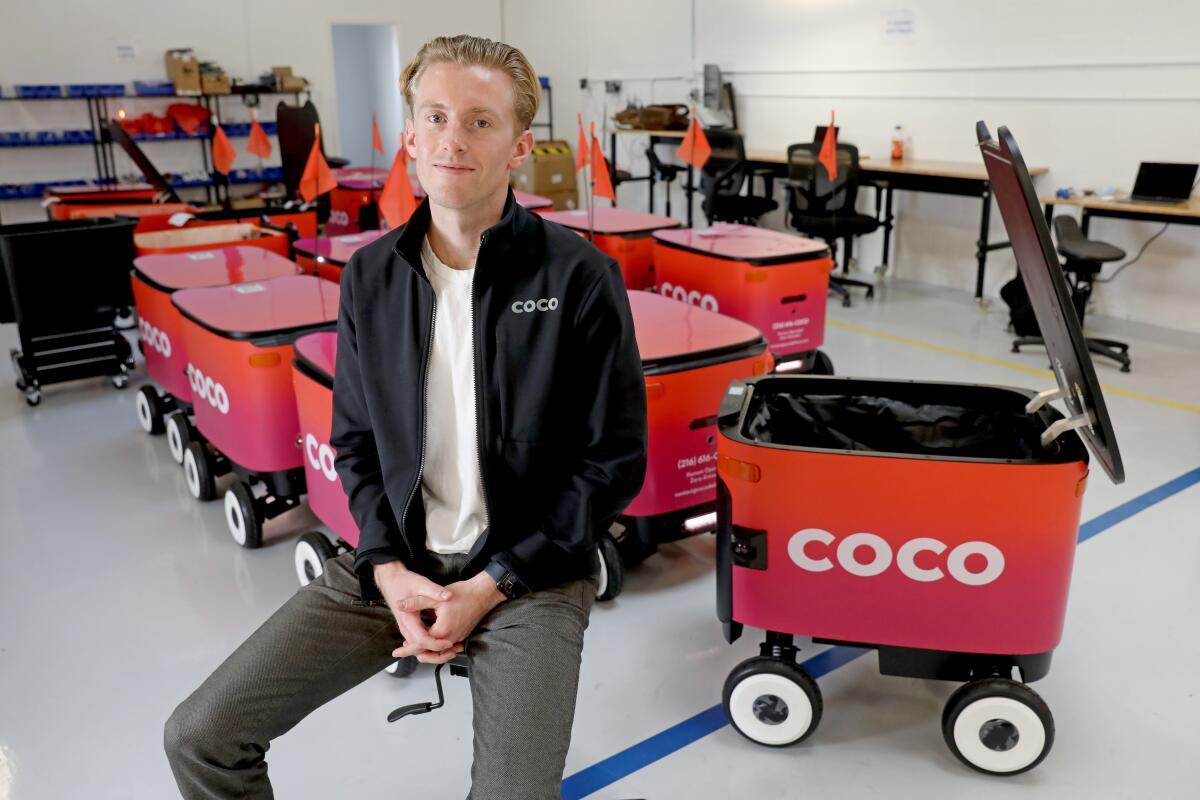 Zach Rash, CEO/co-founder of Coco, with the latest evolution of robots at the facility 