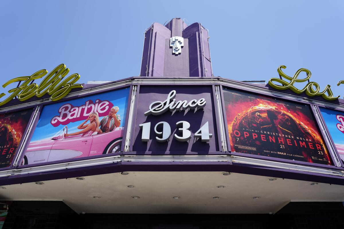 A classic movie-theater marquee with the posters for 'Barbie' and 'Oppenheimer.'