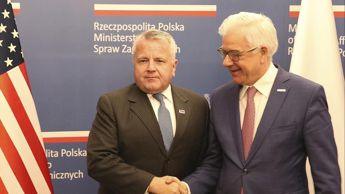 U.S. Deputy Secretary of State John Sullivan, right, shakes hands with Polish Foreign Minister Jacek Czaputowicz in Warsaw on Wednesday.